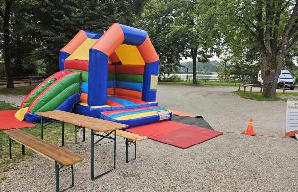 Familienspaß im Gasthof Krieger: Große Hüpfburg und Spielplatz für unsere kleinen Gäste Bunte Hüpfburg und Kinderspielplatz im Außenbereich des Gasthofs Krieger in Mariaort, direkt neben dem Hotel gelegen.