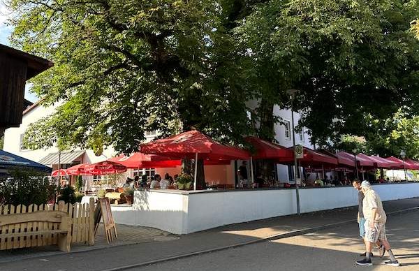 Naab-Donau Mündung: Entspannte Radlpause im Biergarten Mariaort Biergarten unter großen Kastanienbäumen an der Mündung von Naab und Donau mit Blick auf die Radbrücke Mariaort bei Regensburg.