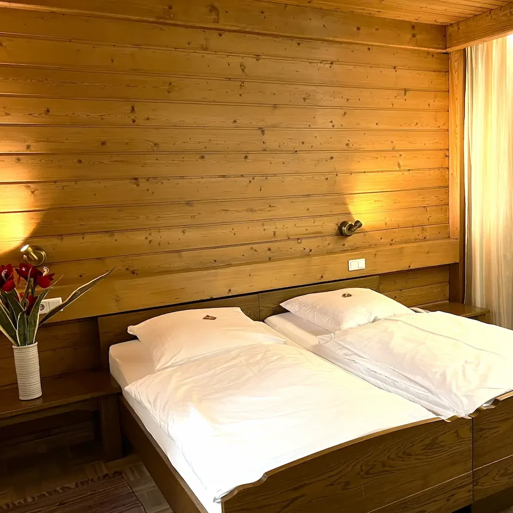 Komfort-Doppelzimmer mit Balkon – Entspannen in Mariaort. Hell eingerichtetes Doppelzimmer im Hotel Krieger mit Doppelbett, Sitzgelegenheit, TV und Zugang zum Balkon.