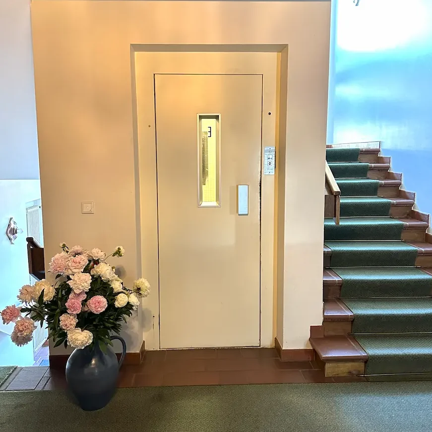 Uriges Hotel-Treppenhaus mit modernem Lift im Hotel Krieger